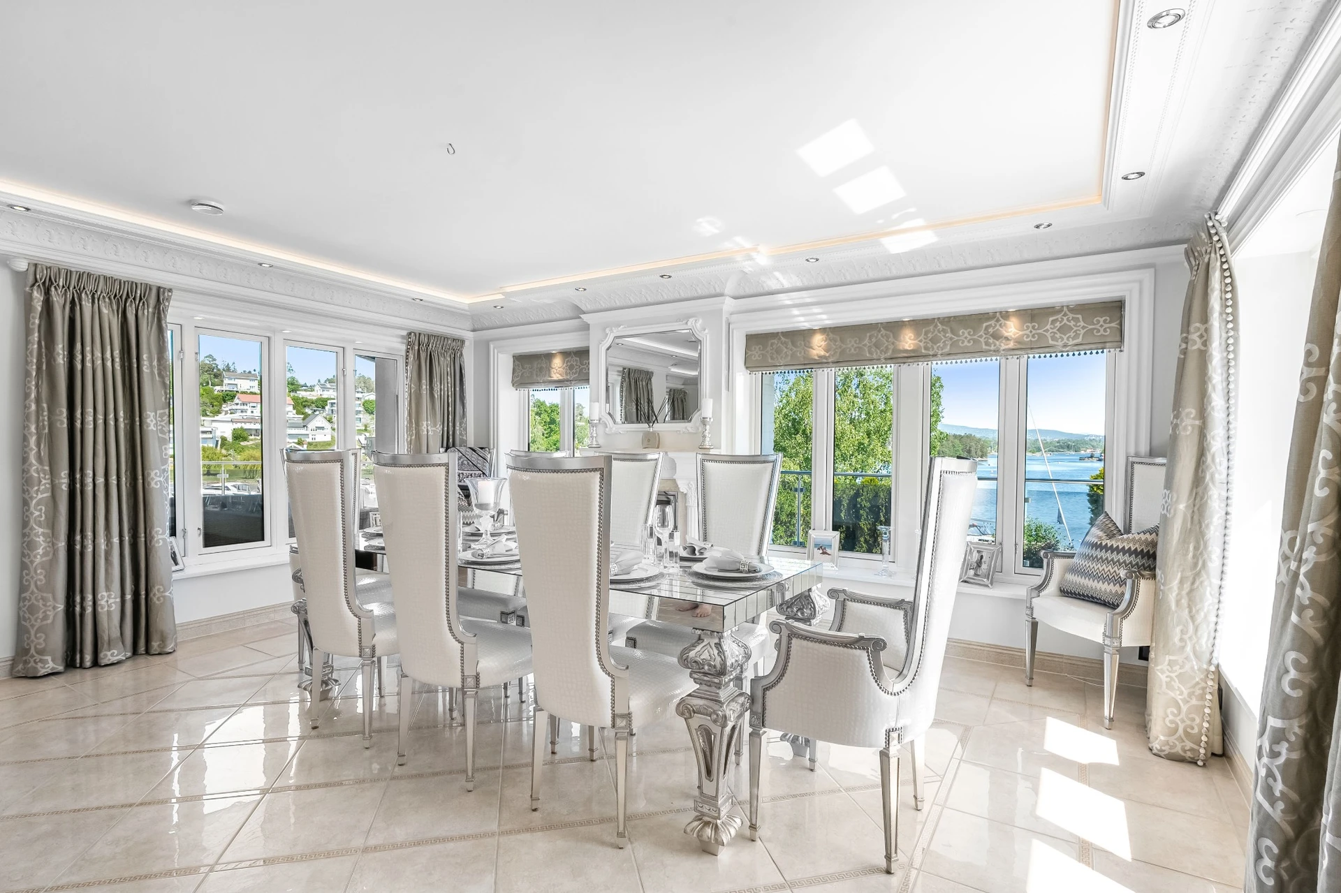 Elegant dining room with mirrored table and waterfront views